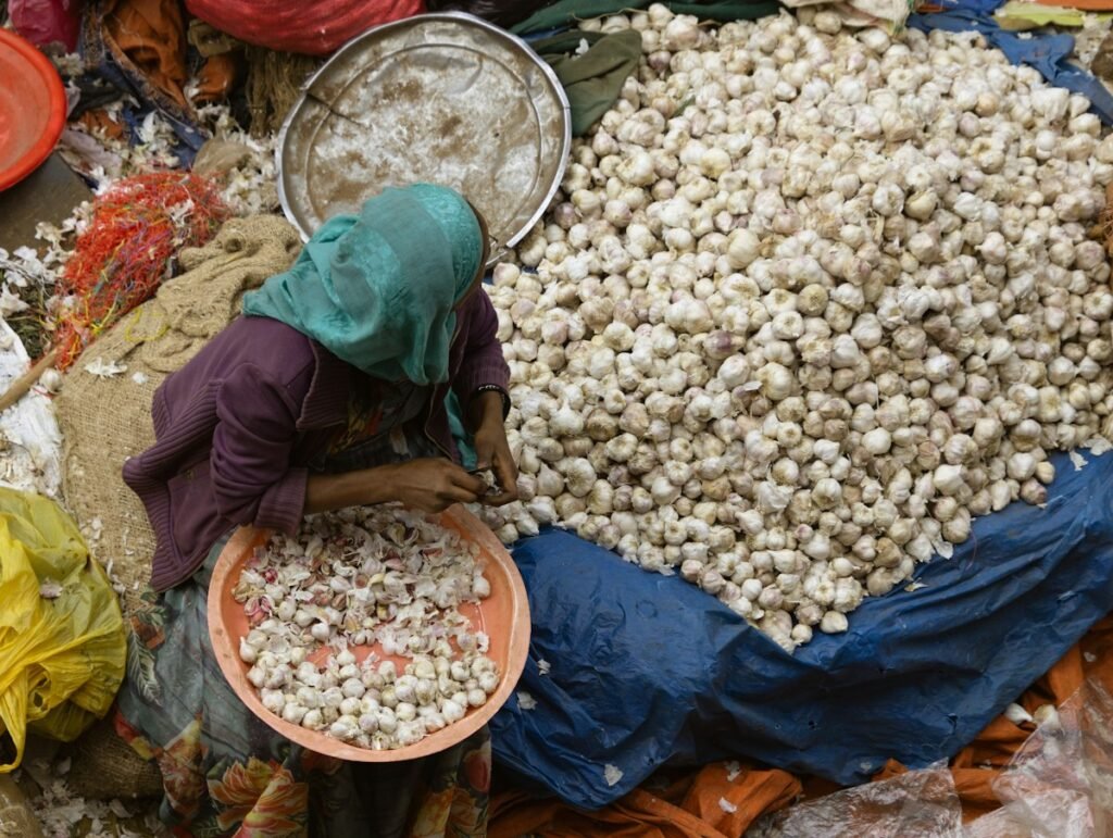 Woman sorting produce at an African food market – demand for imported staple foods from Brazil