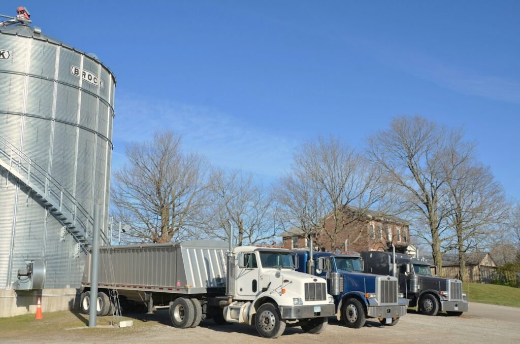 Semi-trucks parked beside a large grain silo – inland logistics from farm to Brazilian export port