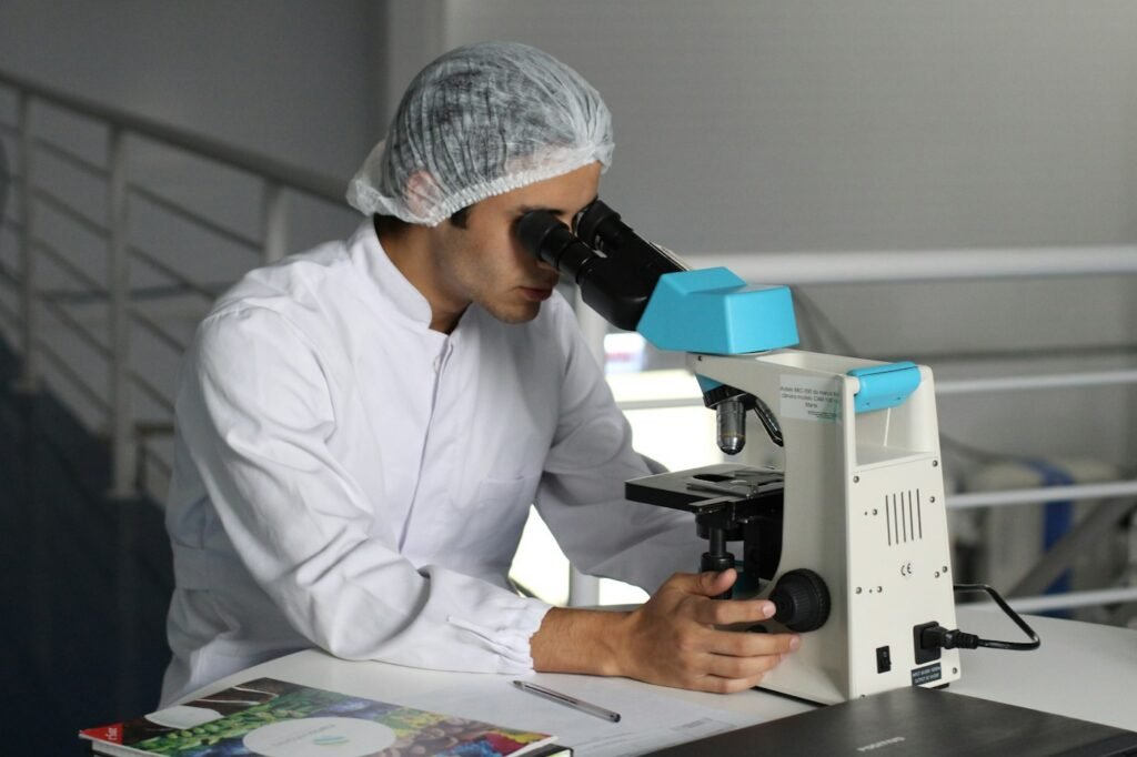 Laboratory technician analysing a commodity sample under a microscope – quality analysis and inspection