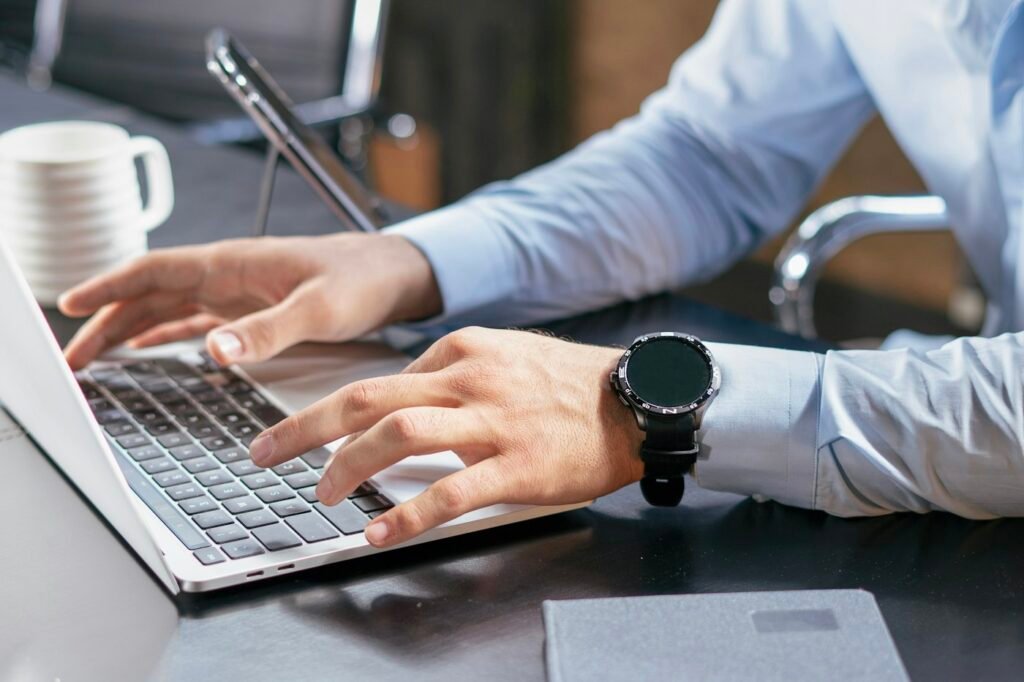 Trade coordinator typing on a laptop – buyer communication and shipment tracking updates